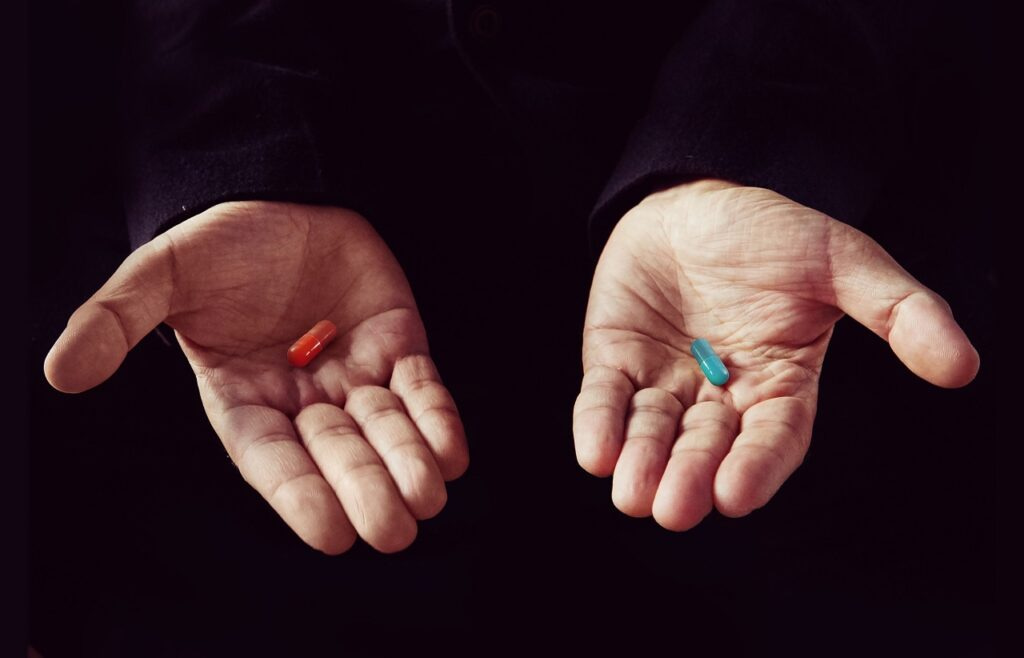 competitive as developer Red tablet in the left palm blue pill in his right hand
