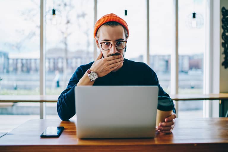 data science course Emotional hipster guy in spectacles read amazing news on laptop computer while working remotely, caucasian man shocked with sales in web store for modern devices and gadgets checking mail on netbook
