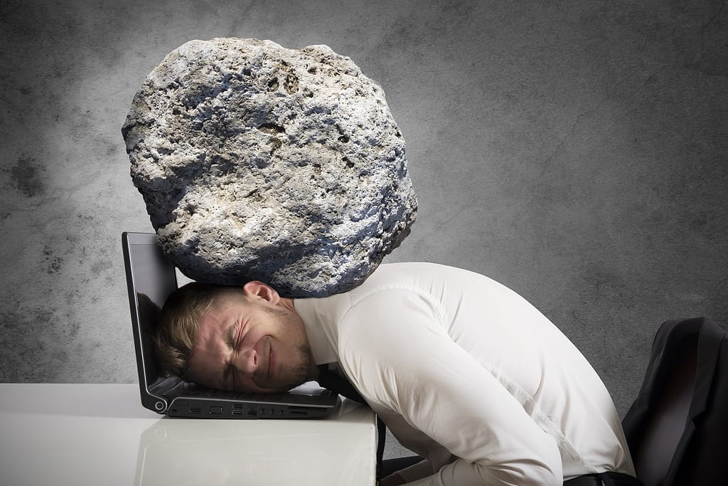 Concept of stress with businessman with a rock on the head